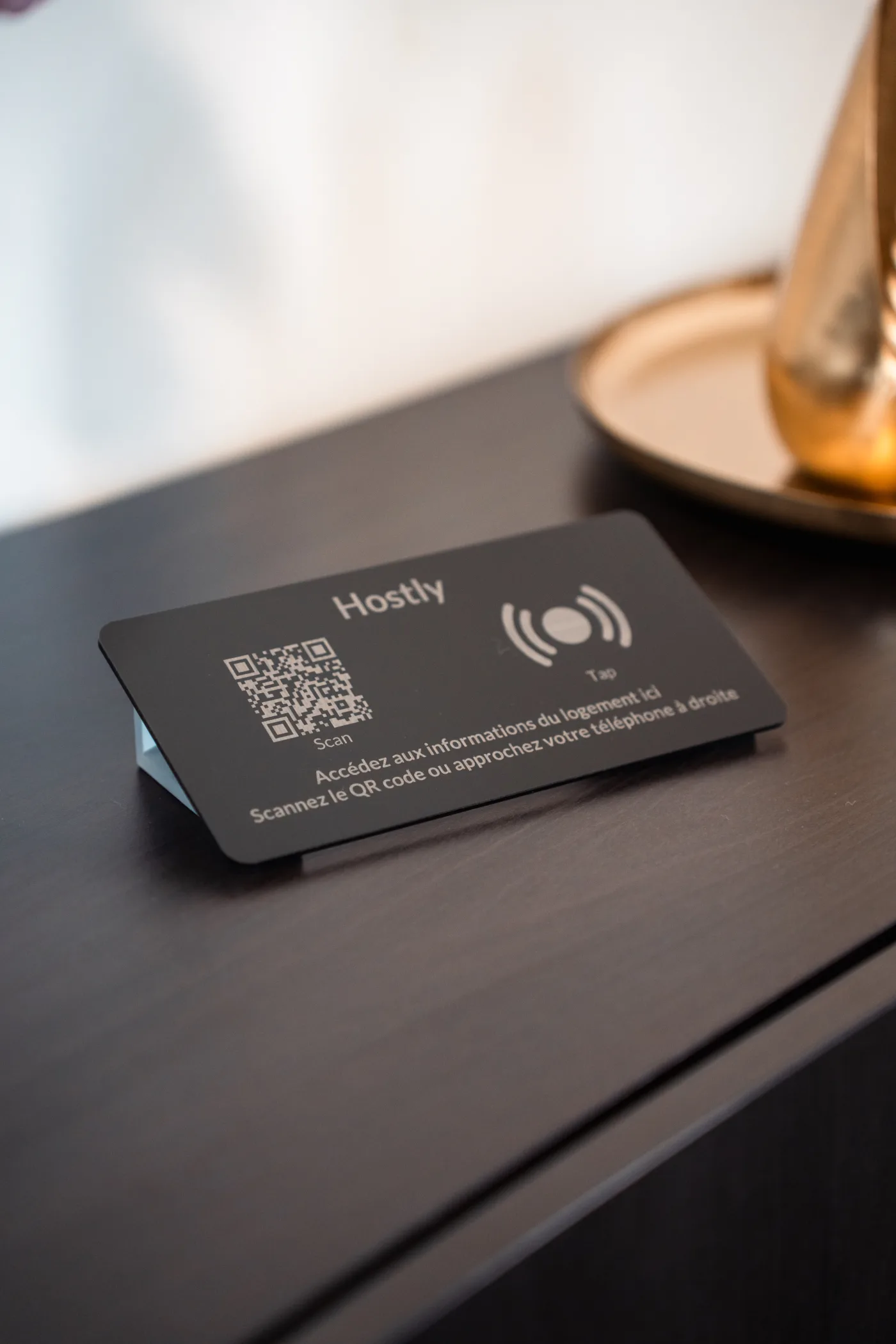 Totem Hostly en plexiglas noir mat posé sur une tablette